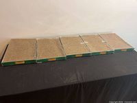 Five sealed Lemax ground cover mat packages on table