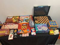 Full lot overview on tabletop with all boxed games, chess set, cards and tiles visible