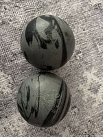 Front view showing Cobra logo and marbled gray/black pattern on both balls