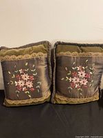 Front view of both pillows showing embroidered floral design and materials
