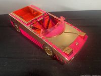 Top and side view of pink and gold convertible doll car