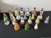 All 21 porcelain miniature girl figurines and bells grouped for full view
