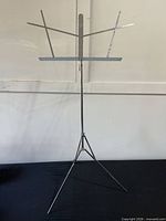 Full view of assembled chrome music stand on tripod base