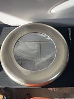Front view of round silver brushed nickel framed mirror