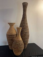 Three woven floor vases grouped together