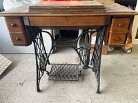 Full view of oak cabinet on Singer cast-iron treadle base, four drawers visible