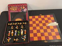 Chess set showing tin lid, tray with pieces and board