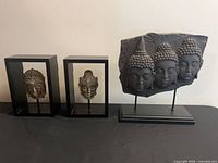 All three Buddha head sculptures on table