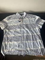 Entire shirt laid flat showing pattern, short sleeves, front buttons