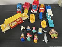 Full assortment of vehicles, camper, and Little People figures displayed on table