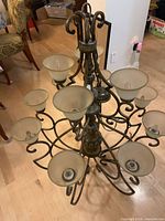 Full chandelier showing metal frame, frosted glass shades, overall structure