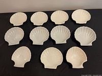 All 11 white porcelain shell-shaped dishes top view