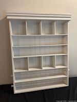 Front view of white wall-mounted cubby shelf showing arrangement of compartments