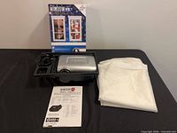 Projector, power cord, folded screen, manual and box overview
