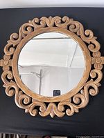 Front view showing carved wood frame and mirror glass