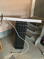 Full view of 36-inch LED shop light hanging by chains with power cord attached