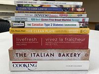 Stack of 11 health-themed cookbooks, spines visible