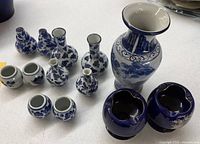 all 13 blue-on-white ceramic pieces arranged on table