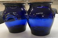 two cobalt blue glass canisters with cork lids standing side by side