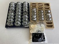 Overview of glass tealight holders in trays and sealed bag of tealights
