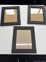 Front view of three black 8" x 10" photo frames on table