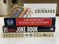 Stacked view of three books and cribbage game box