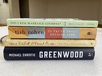 Books stacked showing titles and authors