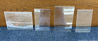 All four clear acrylic photo holders in a row showing different sizes and orientations