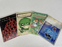Front covers of all four Christmas piano sheet-music books