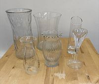 All six clear glass vases grouped