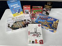 All board games, trivia decks and card shuffler laid out on table