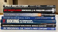Spine view of seven hardcover aviation and military books