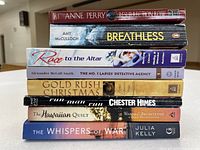 Stack of eight paperback novels showing spines with titles and authors