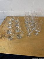 Group of nine dessert bowls and eight stemmed glasses on table