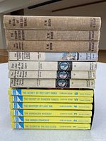 Stacked side view of 13 Grosset & Dunlap hardbacks showing spine titles and authors