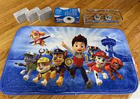 All items overview: Paw Patrol bath mat, three wrapped pumice stones, boxed ice bag, chrome shower shelf