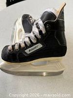 Left-side view of one skate showing Bauer branding, black upper, white holder and steel blade