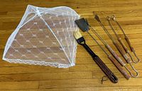 All items laid out: collapsible mesh food cover and five BBQ utensils