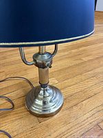 Front view of brass desk lamp, cord visible