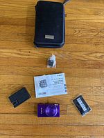 Lot overview showing camera, charger, battery, manual, strap, case