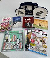 All items laid out: three cat-illustrated bags, five books, three magazines