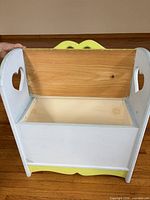 Lid open revealing natural wood underside and storage compartment