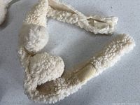 Close view of white woolly headband with ears and hook-and-loop ends