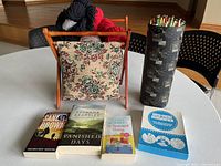 Overall lot showing knitting basket filled with yarn, needle container, magnifier package and three books