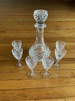 Full set showing decanter with stopper surrounded by six cordial glasses