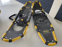 Pair of larger and smaller Faber snowshoes showing frames, decking, bindings