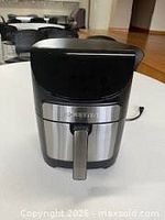 Front view of Gourmia air fryer showing stainless front, handle, cord