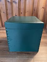 Front view of green vinyl storage cube showing rivets