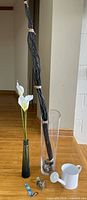 Overall lot showing both vases, lilies, sticks, watering can, hummingbird feeder