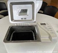 Bread maker opened showing interior pan and lid window